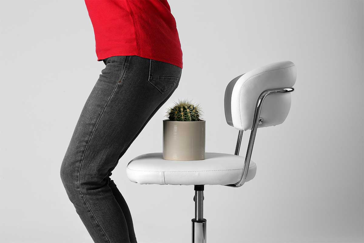 Woman sitting down on chair with cactus