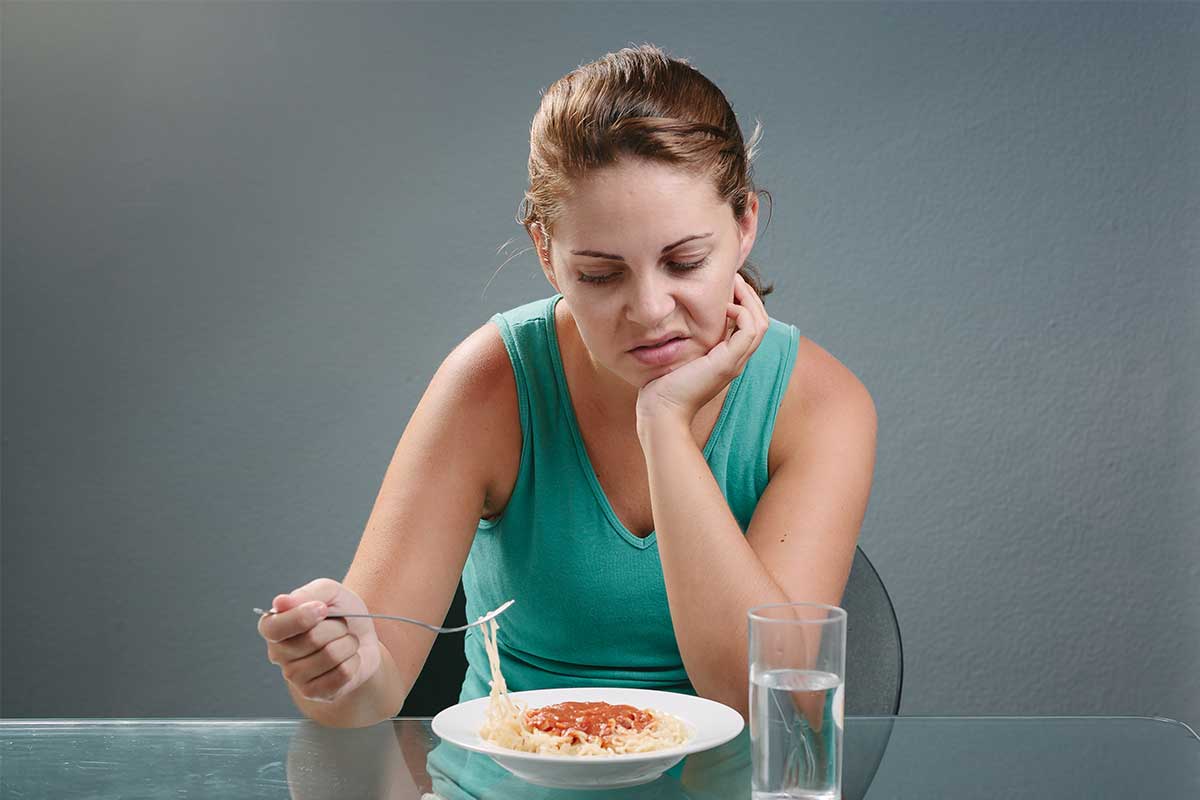 Portrait of woman with no appetite in front of the meal