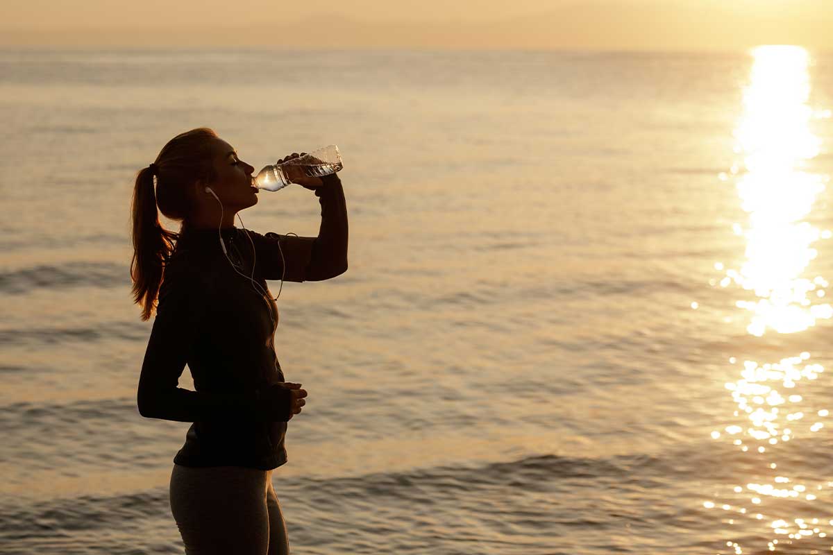 Thirsty athletic woman drinking water