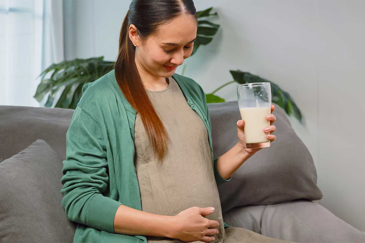 Asian pregnant woman drinking milk for the better health