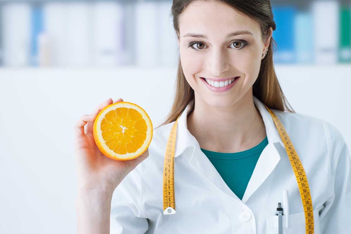 Nutritionist holding a sliced orange